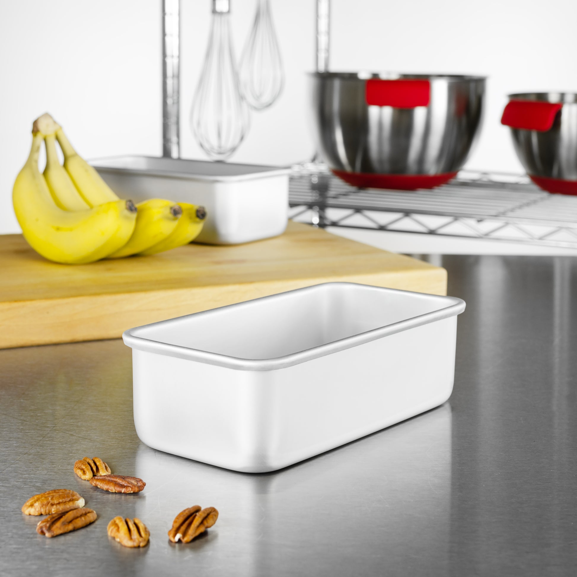 Bread and loaf pans with walnuts, bananas, tools and bowls in a bakery