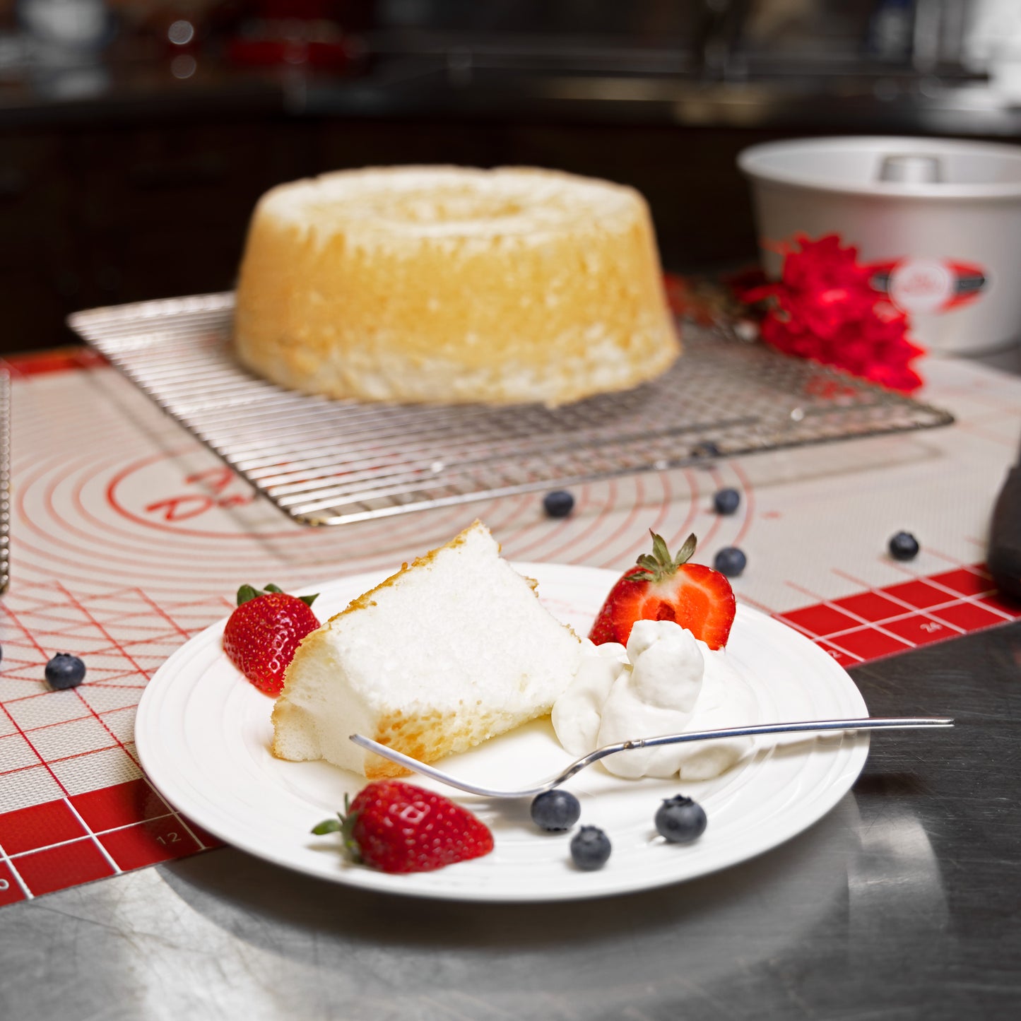 Angel Food Cake plated with strawberries and blueberries in a bakery