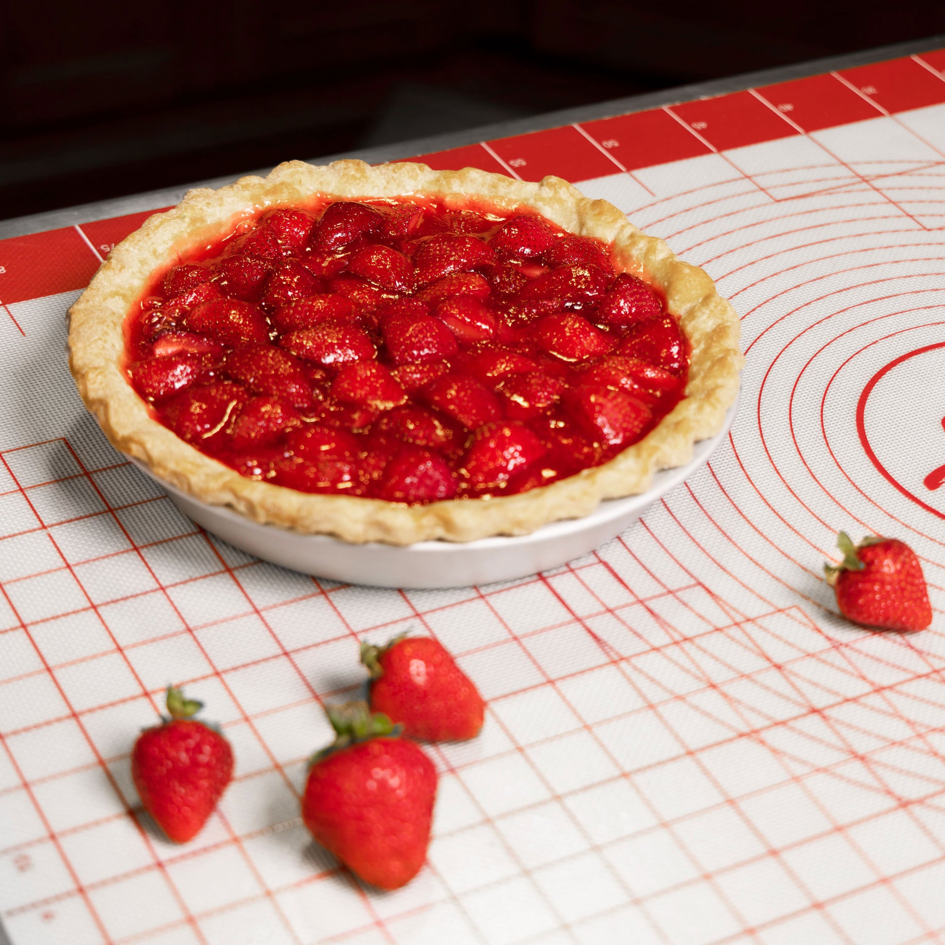 A summer strawberry pie with strawberries in a commercial kitchen