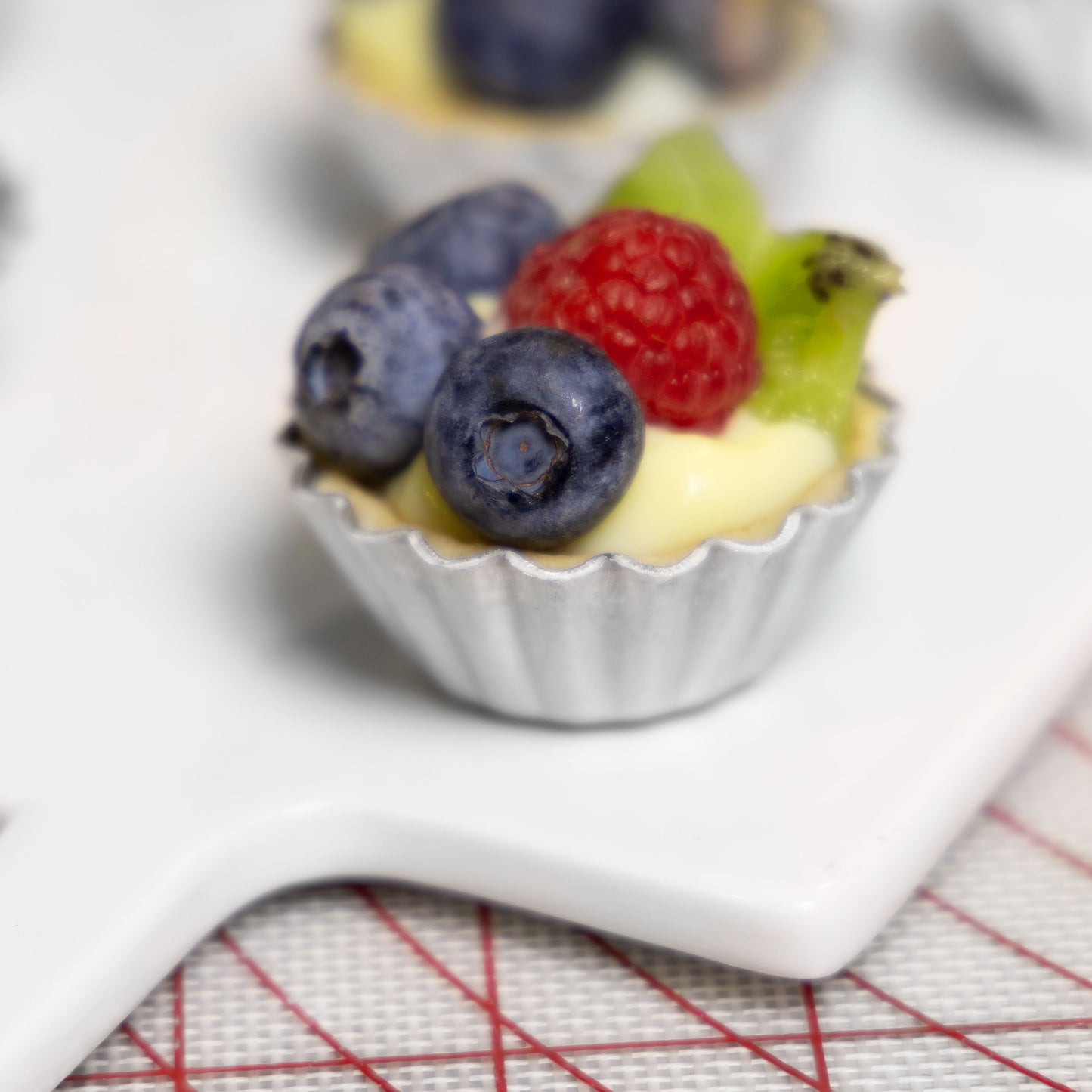 Mini fruit cheesecake tart with blueberries, rasberries and kiwis