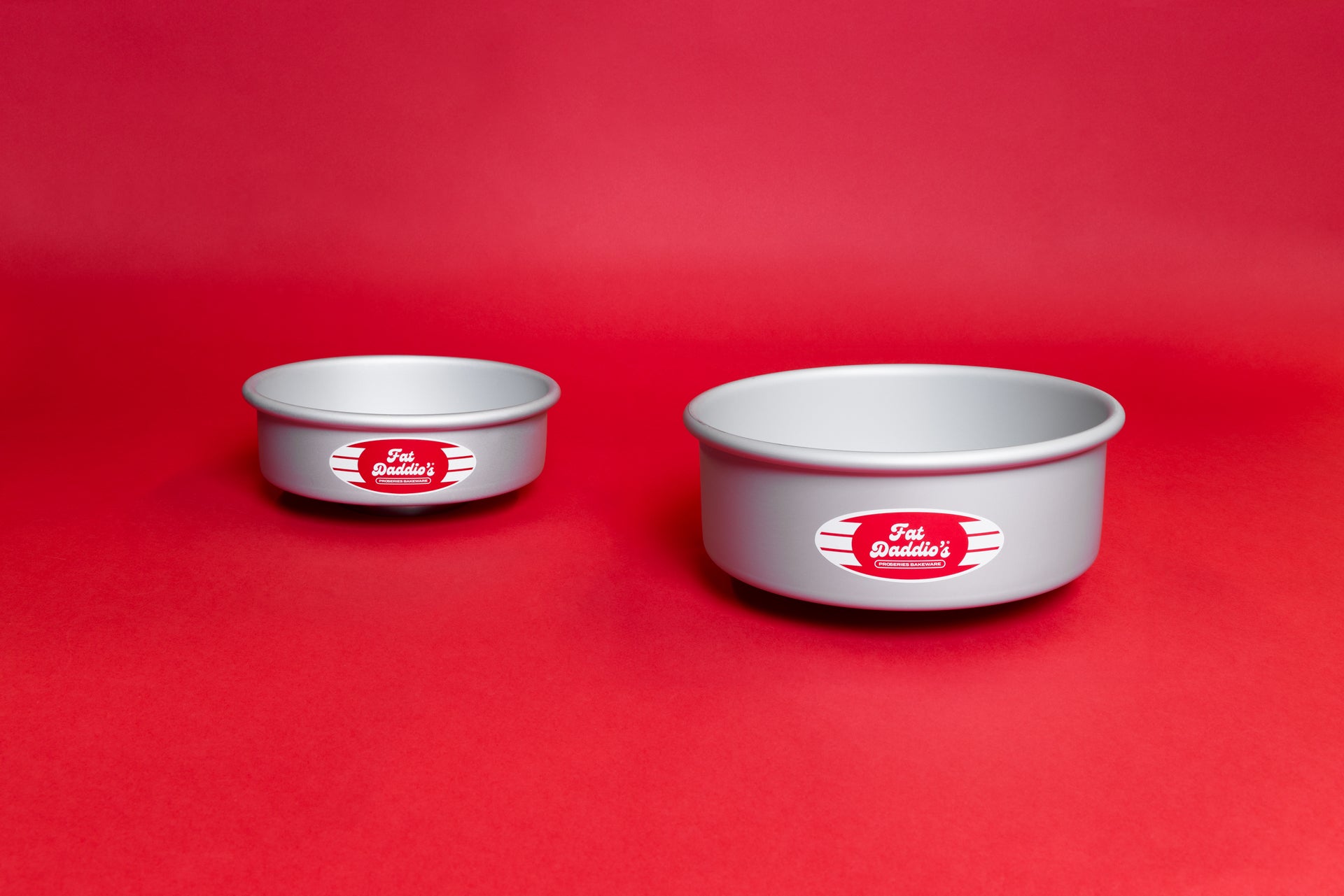 Two round cake pans on a red backdrop