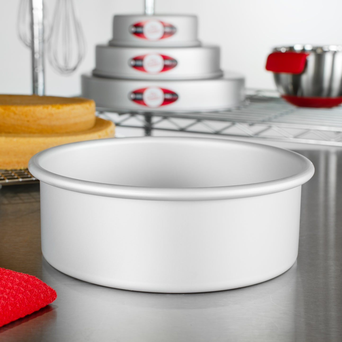 Round cake pans with round cakes, tools and bowls in a bakery