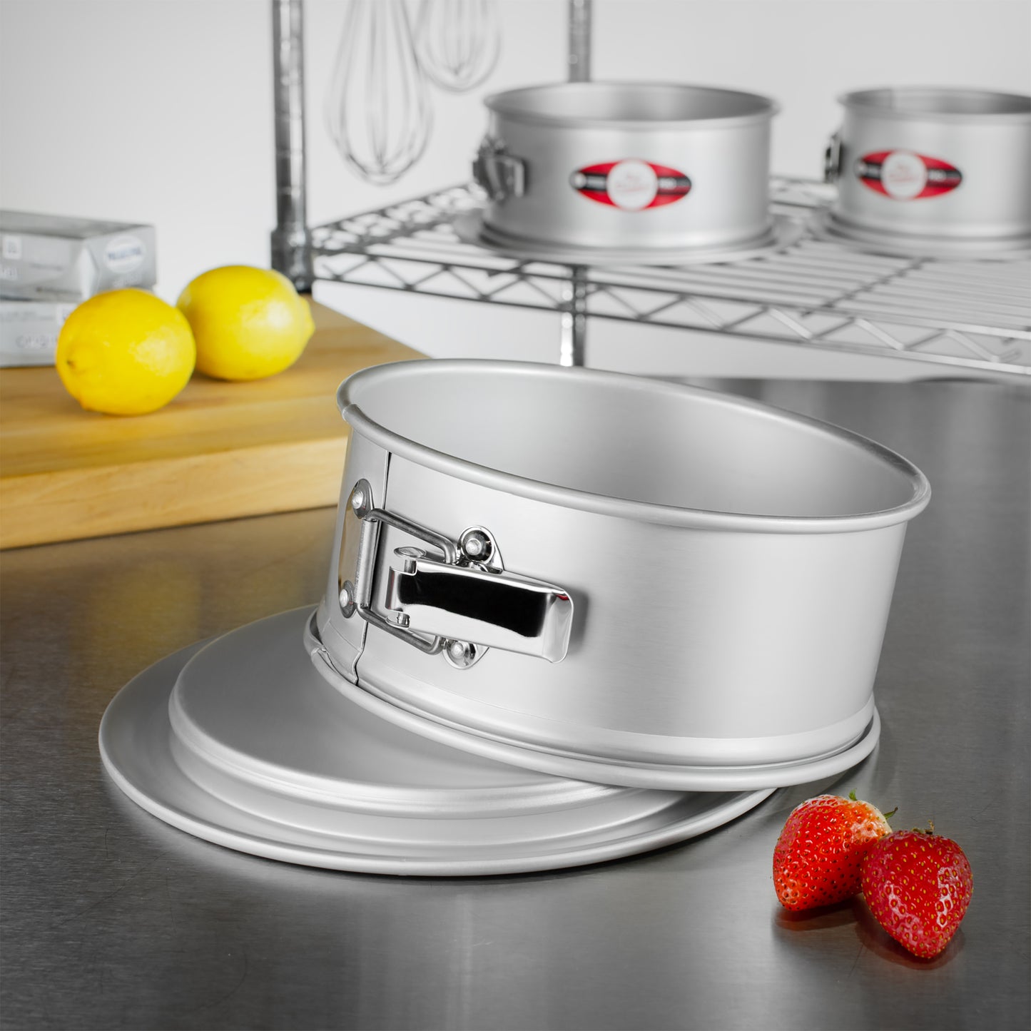 Chocolate cheesecake in a round springform cake pan with removeable bottom sitting on a silicone work mat in a commercial kitchen